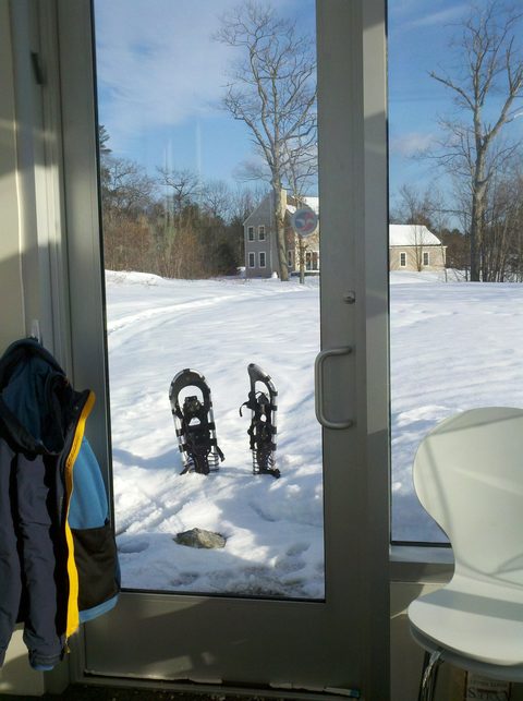 Snowshoes beside a glass door in winter