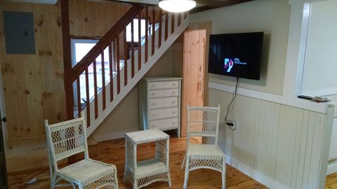 Staircase and wall-mounted television in the living area