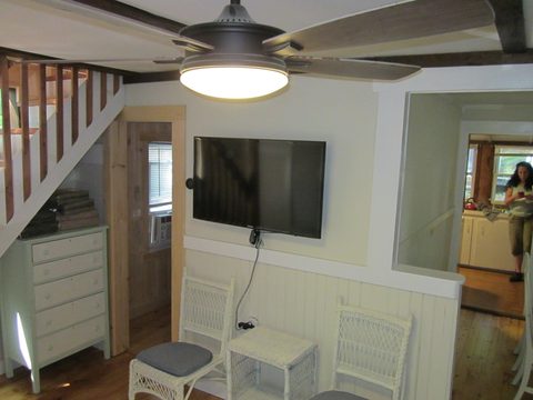Living area with ceiling fan and television